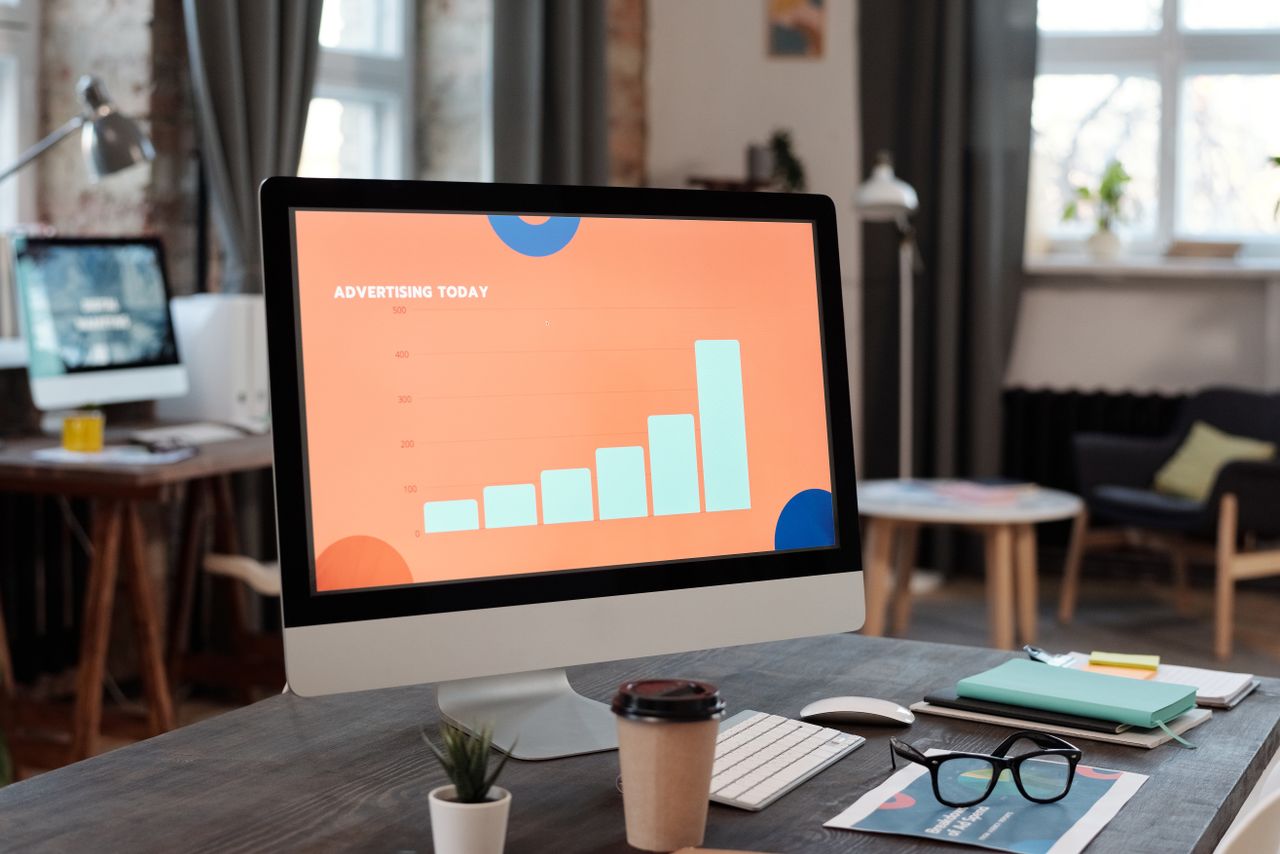 Contemporary office desk setup with computer displaying a business chart.